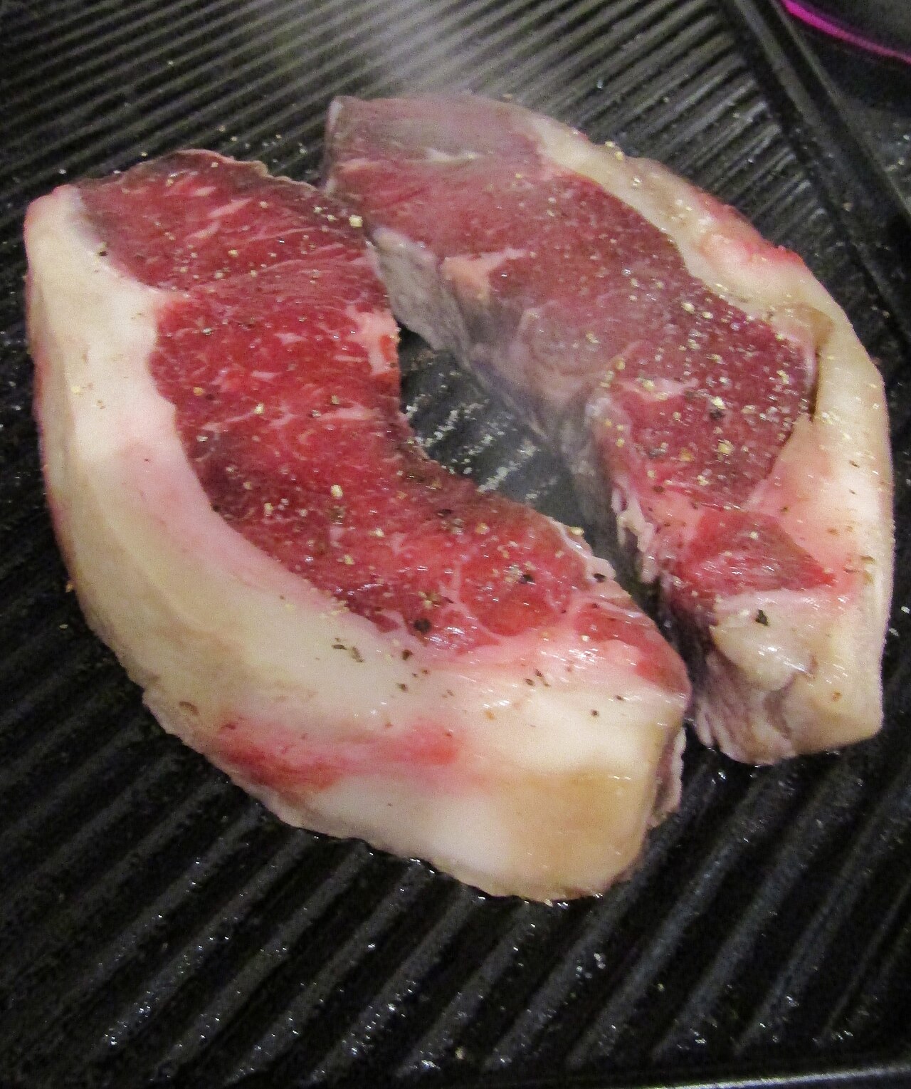 Steaks beim Garen auf einer geriffelten Grillplatte
